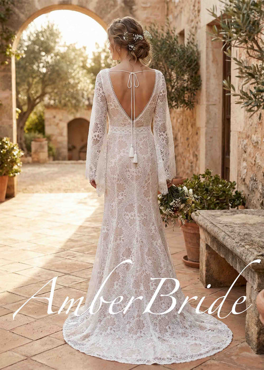 Back view of a boho mermaid wedding dress with lace, bell sleeves, and a deep open back with tie detail.