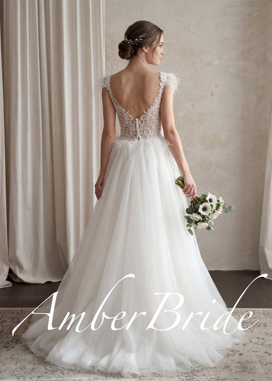 Boho A-line wedding dress with a deep-back lace bodice, feather-adorned straps, and a soft tulle skirt.
