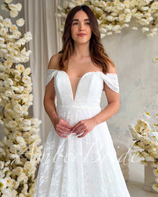 Romantic A-Line Lace Wedding Dress with Off-Shoulder Sleeves and Deep V-Neckline – front view, styled | AmberBride