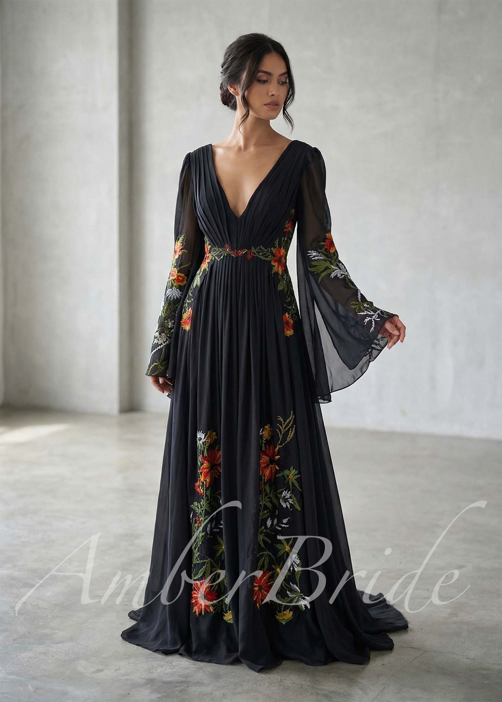 Black A-line gown with V-neck, flowing bell sleeves, and vibrant floral embroidery on chiffon fabric.