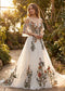 Off-shoulder chiffon wedding dress with colorful floral embroidery, V-neckline, spaghetti straps, and flowing skirt.
