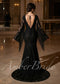 Back view of a black lace mermaid wedding dress with deep open back, tie detail, and long fringed bell sleeves.