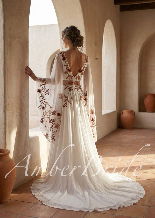 Back view of a boho wedding dress with rust floral embroidery, wing sleeves, v-neck, and floor-length chiffon skirt.