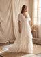 Off-white chiffon A-line wedding dress with a V-neckline, flutter sleeves, and layered draped skirt.
