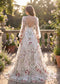 Back view of an A-line wedding dress with a deep V-back, long puffy sleeves, and colorful floral embroidery.