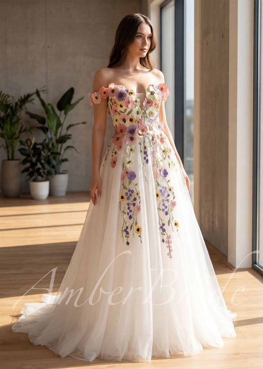 Off-shoulder A-line wedding dress featuring colorful 3D floral appliques and embroidery on a white tulle skirt.