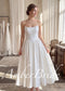 White tea-length wedding dress with a strapless satin corset bodice and a full, pleated basque waist skirt.