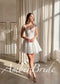 White lace knee-length wedding dress with a sweetheart neckline, corset-style bodice, and flared skirt.