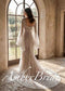 Back view of a boho mermaid wedding dress with square back, bell sleeves, and intricate white botanical lace.