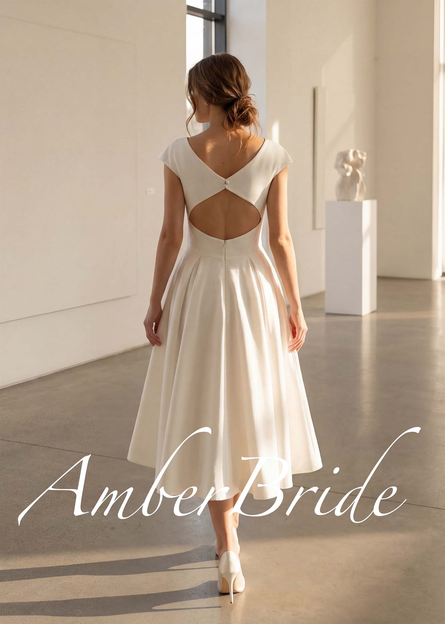 White satin tea-length A-line dress with cap sleeves and a deep open back featuring a single button closure.