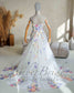 A-line wedding dress with off-shoulder sleeves, featuring colorful floral embroidery on white tulle with a long train.