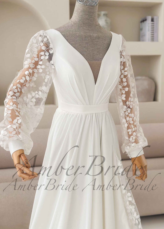 Minimalist white A-line wedding dress with a V-neck, sheer lace bishop sleeves, and a draped chiffon skirt.