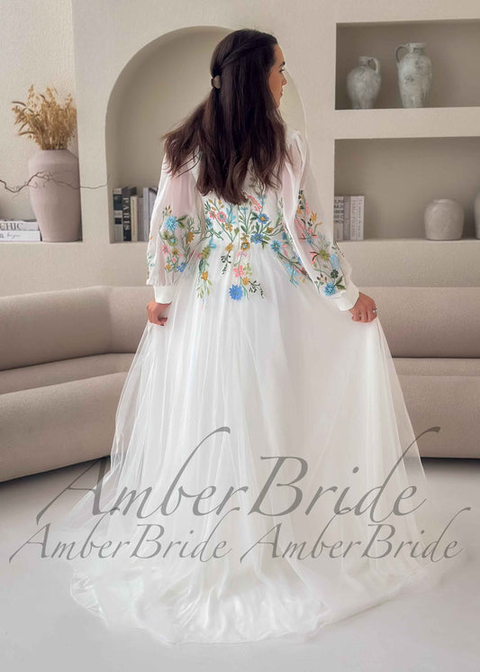 A-line white tulle wedding dress with long sleeves and colorful floral embroidery on the back and sleeves.