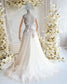 Nude A-line wedding dress with open back, square neckline, and pastel floral embroidery on tulle fabric.