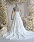 Back view of a white strapless chiffon wedding dress on a mannequin, featuring a ruched bodice and flowing skirt.
