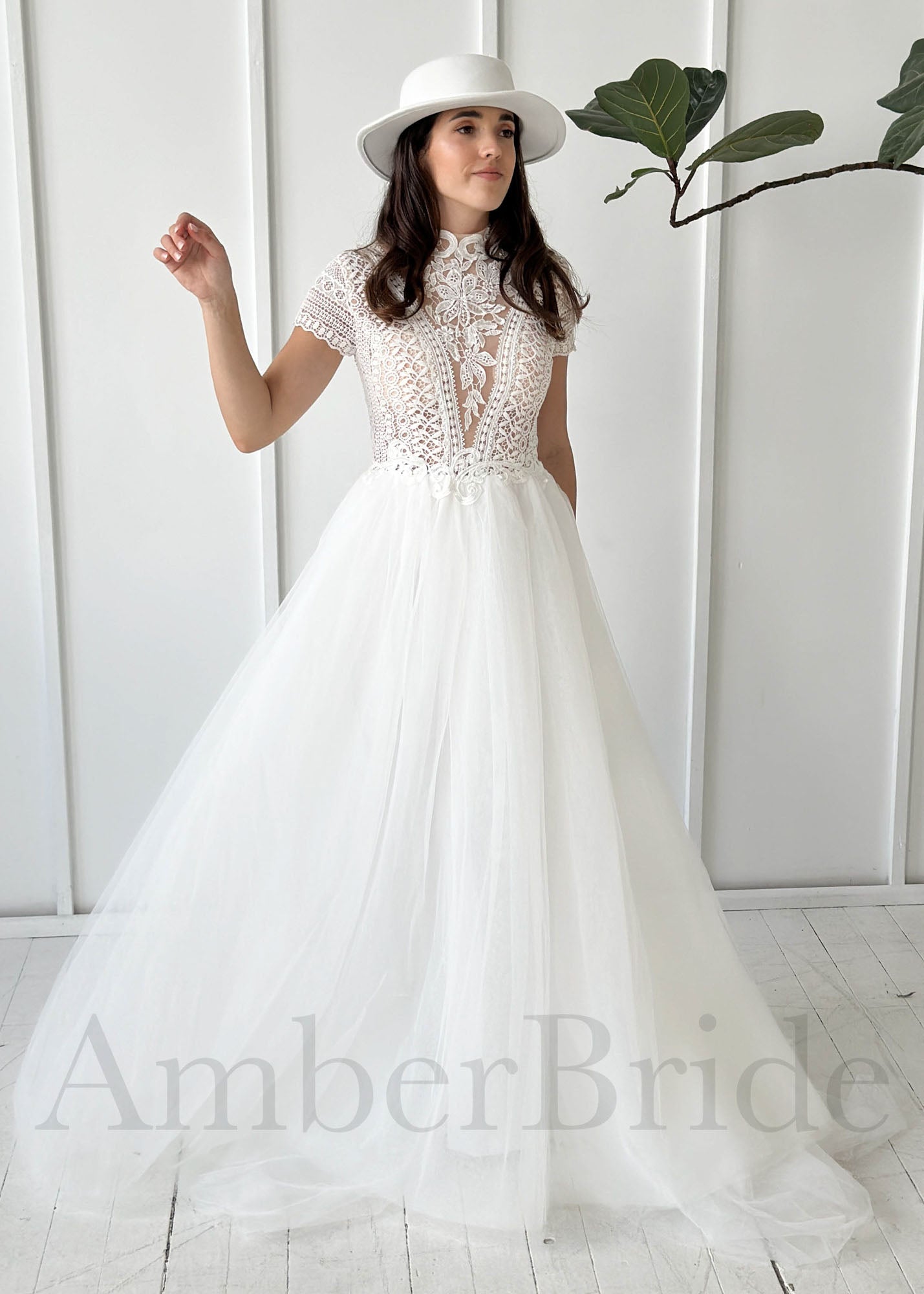 Boho A-line wedding dress with a lace high-neck bodice, short sleeves, and a full, flowing tulle skirt.