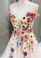 Off-shoulder A-line wedding dress featuring colorful 3D floral embroidery on a white tulle bodice.
